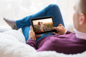 Man sitting on couch watching youtube videos